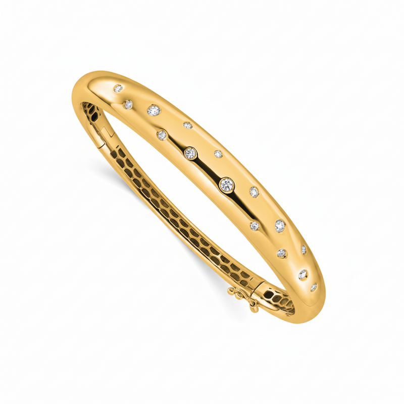 A polished yellow gold hinged bangle bracelet decorated with small round clear gemstones set along the outer band, shown on a plain white background.