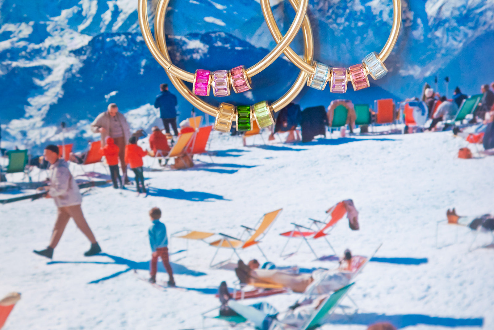 Gold rings with colorful gemstones on a snowy mountain background