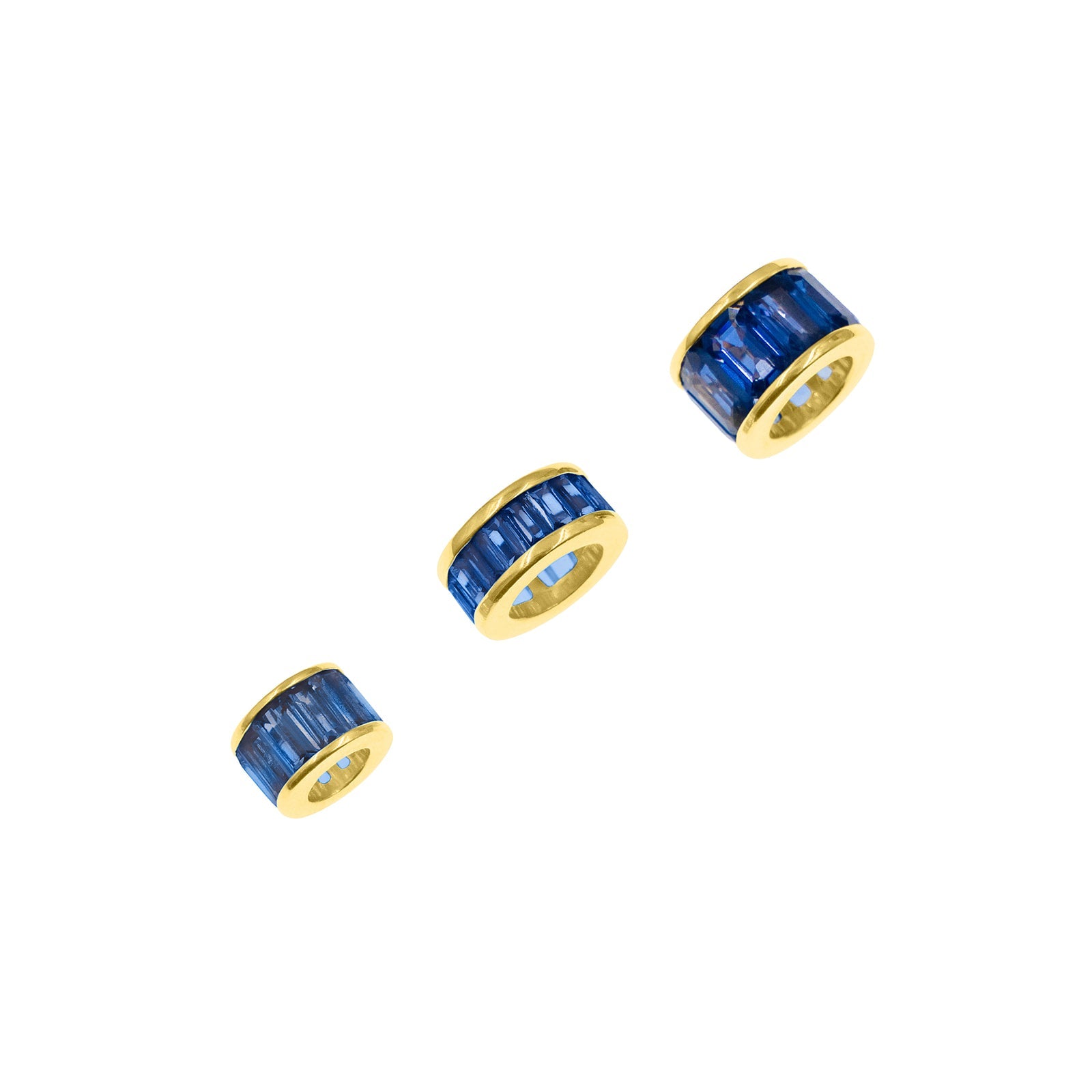 Three cylindrical blue and gold jewelry charms arranged diagonally on a plain white background.