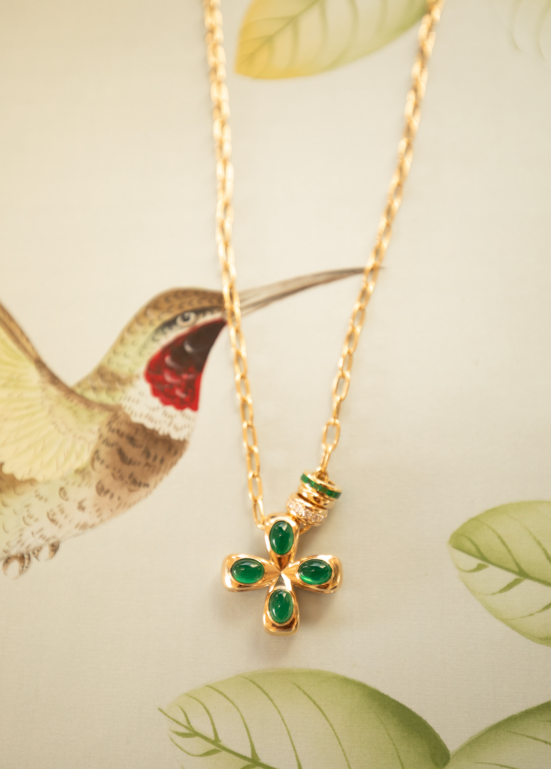 Gold necklace with green gemstone pendant on a nature-themed background in Palm Beach with our Flagler Necklace, Everglade Medium Glider and spacers