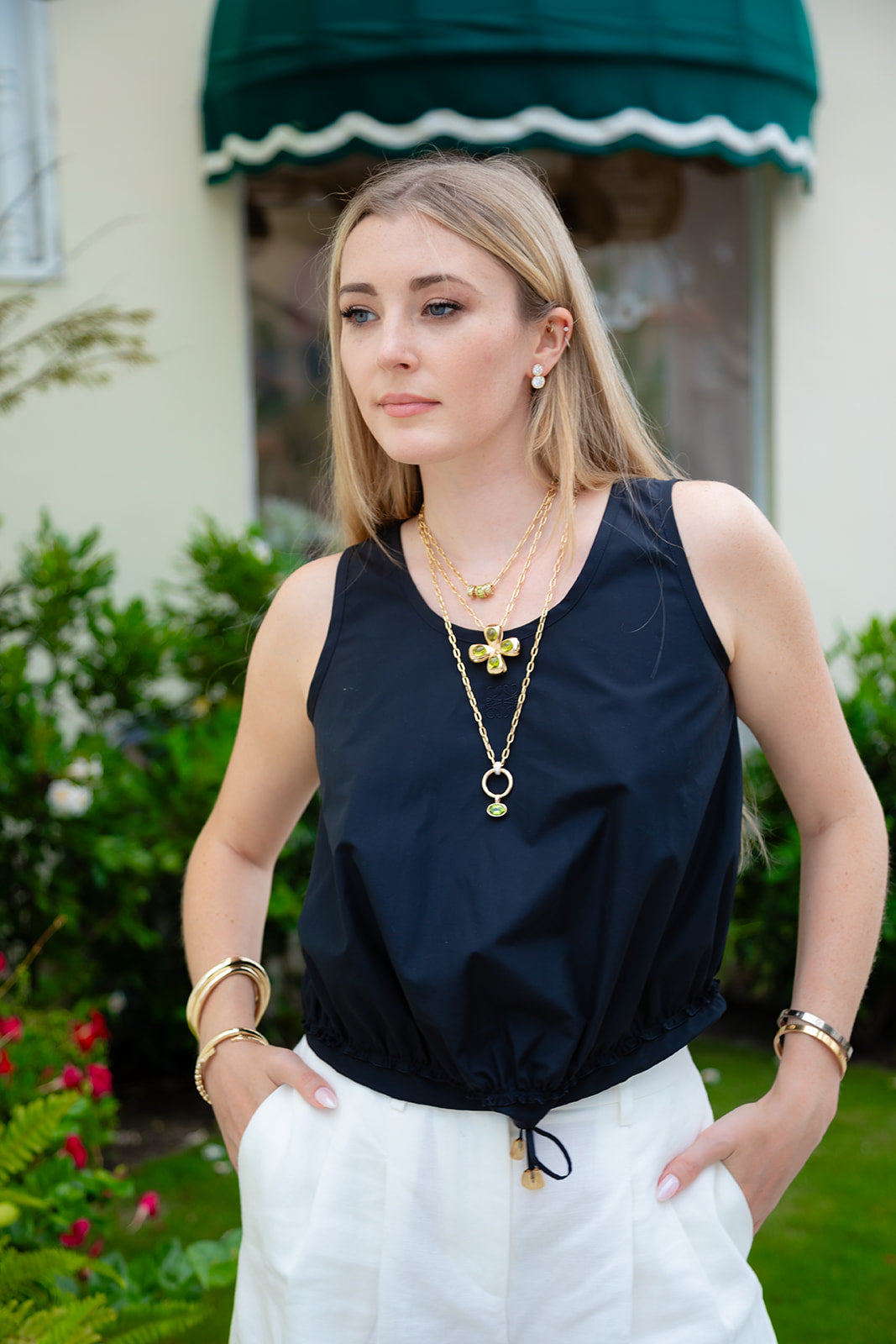 Gold pendant with a green gemstone on a white background, light green peridot set in 14K yellow gold.  Made by design team in Palm Beach, Florida Pelimingo Palm Beach.  Worn on necklace or collar